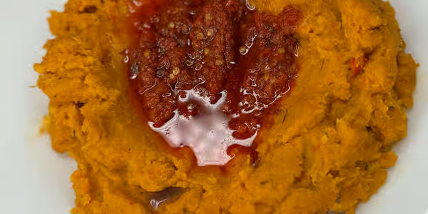 Nigerian yam porridge Asaro with palm oil and assorted meat